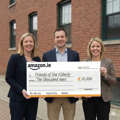 Three people holding a giant presentation cheque at a charity donation event. The oversized cheque shows a €10,000 donation to a local charity.