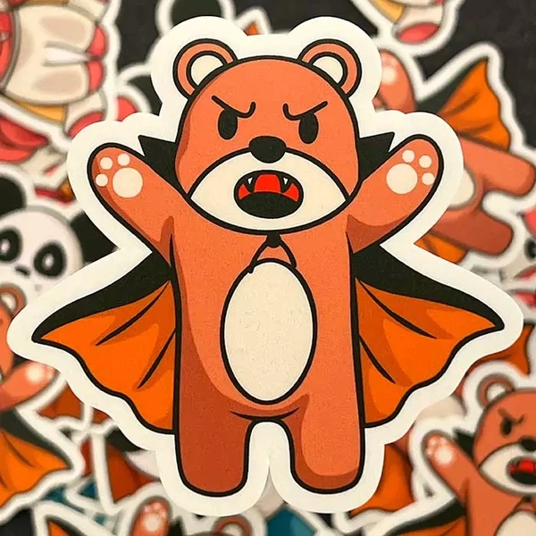 Custom sticker featuring an angry cartoon bear with fangs, dressed as a vampire with a black and orange cape, standing with arms raised. Ideal for unique sticker designs.