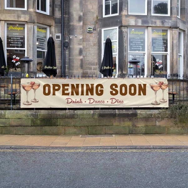 PVC banner on railings advertising a new restaurant opening